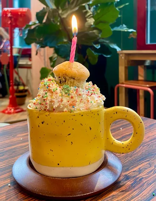 Birthday hot chocolate with whipped cream, sprinkles and a candle